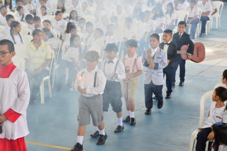 Estudiantes del Colegio Salesiano San Juan Bosco, vestidos como Santo Domingo Savio, participan con devoción en las ofrendas de la Misa en Granada.