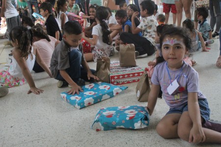  Niños de Pérez Zeledón reciben obsequios durante la Fiesta Navideña organizada por el grupo ESCOGE del Centro Don Bosco. Un momento lleno de esperanza y gratitud en el espíritu de la Navidad.