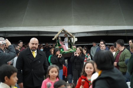 Feligreses participan en la tradicional procesión de la posada durante la Misa de Navidad en la Parroquia El Espíritu Santo.