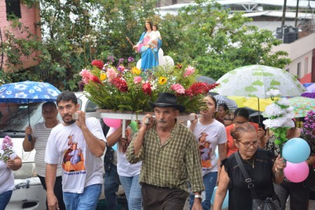 Fieles en procesión llevando la imagen de María Auxiliadora durante la novena en Comayagüela.