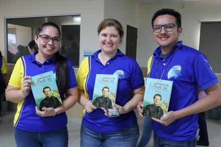 Tres colaboradores de Ciudadela Don Bosco muestran con orgullo las Memorias del Oratorio de San Francisco de Sales, entregadas durante el encuentro motivacional encabezado por el padre Mariano Miranda.