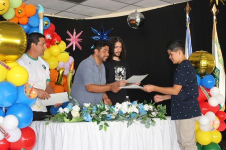 Un participante recibe su diploma en la clausura de “Vacaciones con Don Bosco”.