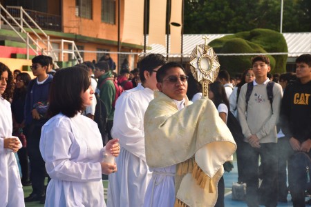 El padre Edwin Tut encabeza la procesión con Jesús Eucaristía durante la solemne celebración del Corpus Christi en el Instituto Técnico Ricaldone.