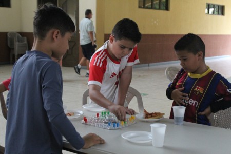 Niños disfrutan de un emocionante juego de mesa durante el 'EPRE Summer Fest' en el Centro Don Bosco.