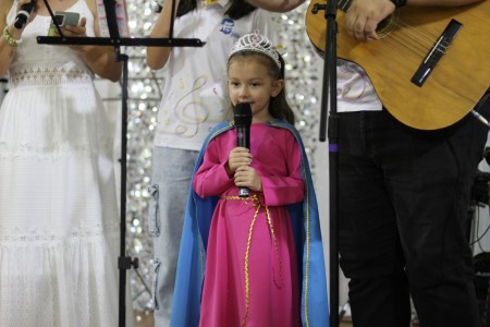 Una niña vestida como la Virgen María Auxiliadora canta a la virgen, durante la celebración en el Centro Don Bosco de Pérez Zeledón.