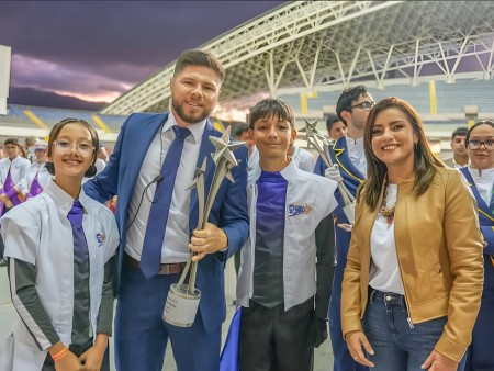 Luis Fernando Solano, director de la banda; estudiantes de CEDES Don Bosco; y Yariela Quirós, vicealcaldesa de San José, celebran el logro tras la espectacular presentación de Forever Rock.
