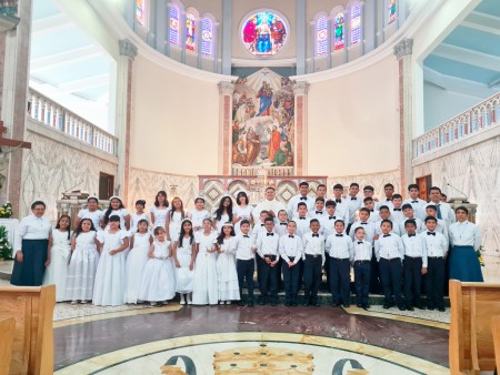 La Primera Comunión celebra la integración de los niños a la comunidad, inspirándolos a vivir los valores del Evangelio bajo el ejemplo de San Juan Bosco y la protección de María Auxiliadora.