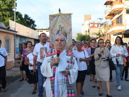 Fieles de San Benito rezan el Rosario de la Aurora durante la procesión por las calles, en honor al cumpleaños de la Virgen María.