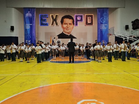 Los estudiantes que forman parte de la Banda Padre Emeterio Serrano del Instituto Técnico Don Bosco se preparan para representar los valores y tradiciones de su patria.