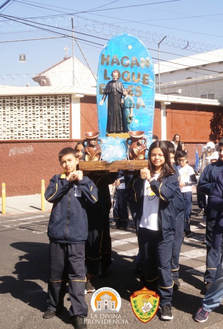 Estudiantes del Liceo Salesiano portan la imagen de Don Bosco durante la procesi&oacute;n por las calles aleda&ntilde;as, como testimonio de fe y esp&iacute;ritu salesiano.
