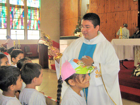 El P. Gabriel bendice a los pequeños con la reliquia del santo. 