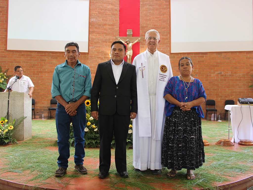 El hermano Oswaldo Tiul Caal junto a sus padre y el padre Antonio de Groot, sdb.