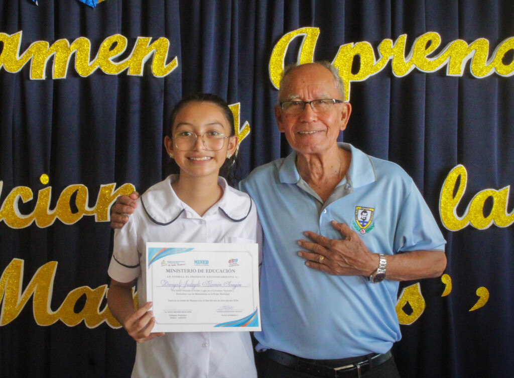 Danyali Alemán Aragón gana Certamen Municipal 2024, el director de la Escuela Anexa San Juan Bosco, padre Mario Madrid, SDB acompaña a la ganadora. 