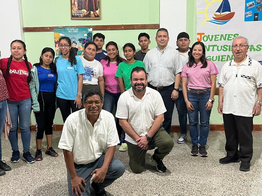 El padre Edward De La O, ecónomo inspectorial, junto a Christian Jiménez y Deborah López, posan con miembros de la comunidad de la parroquia San Benito de Palermo, Petén, durante la visita de animación inspectorial en octubre de 2024