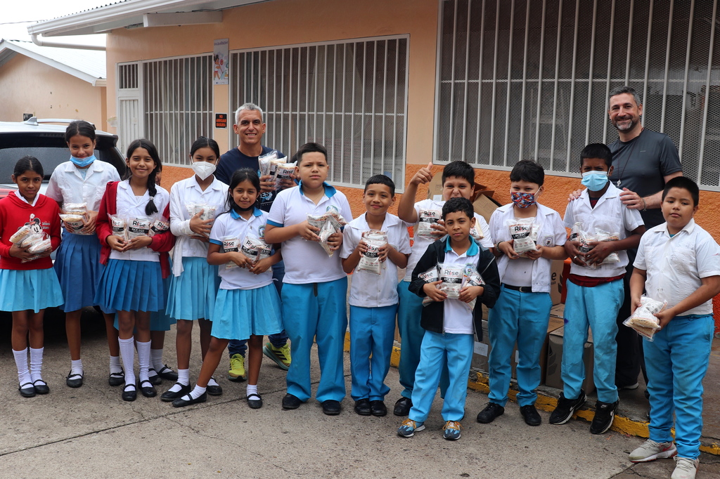 Niños del centro educativo Tiburcio Carías Andino reciben con alegría la donación de arroz de soya gestionada por la Parroquia María Auxiliadora, como parte de una acción solidaria que busca fortalecer su nutrición y bienestar, gracias al apoyo de Salesian Missions.