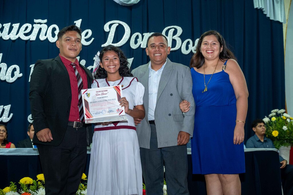 Estudiante de sexto grado celebra su promoción junto su familia y docente.