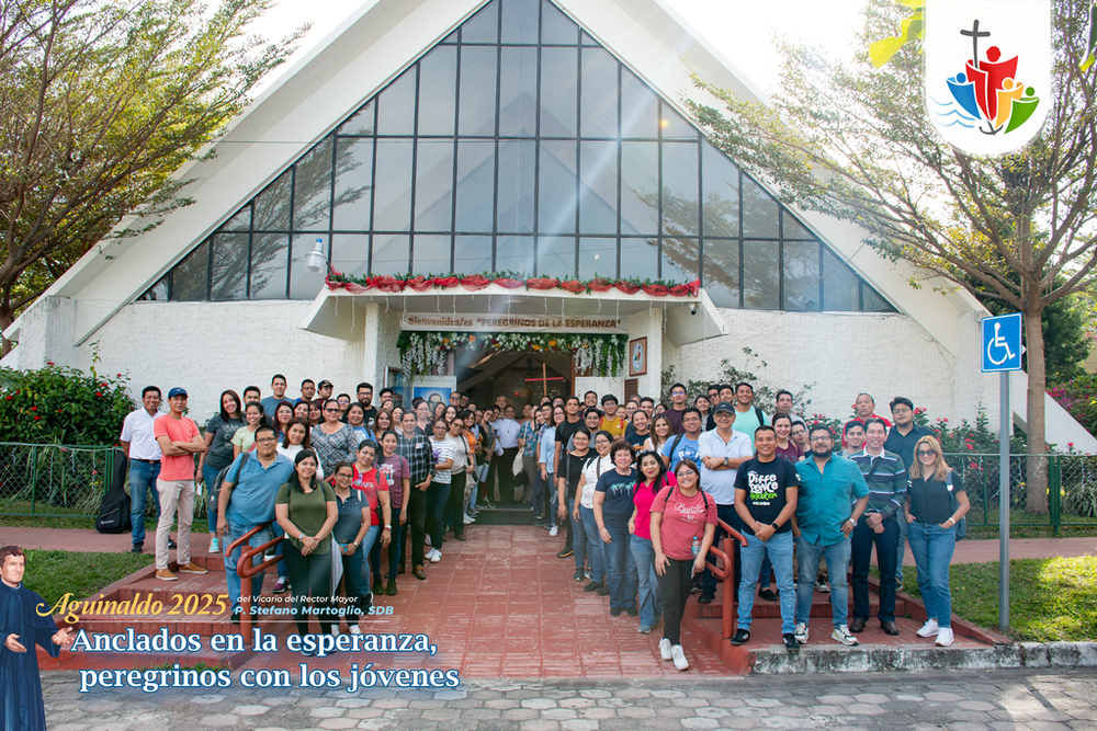 Colaboradores del Instituto Técnico Ricaldone frente a la puerta de la Capilla Martirial de San Óscar Arnulfo Romero, símbolo de fe y esperanza en su peregrinación espiritual.