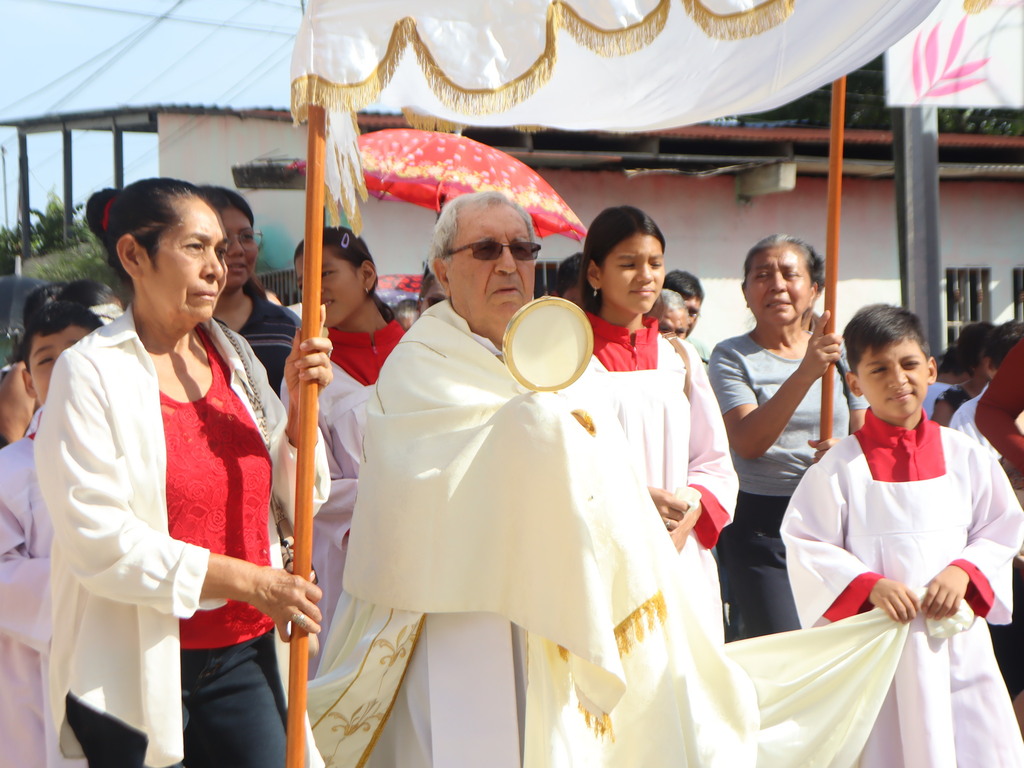 El padre Miguel Giorgio, párroco de San Benito de Palermo, encabeza la procesión de Corpus Christi por las calles de Petén, acompañado por fieles que expresaron su amor y fe en Jesús Eucaristía.