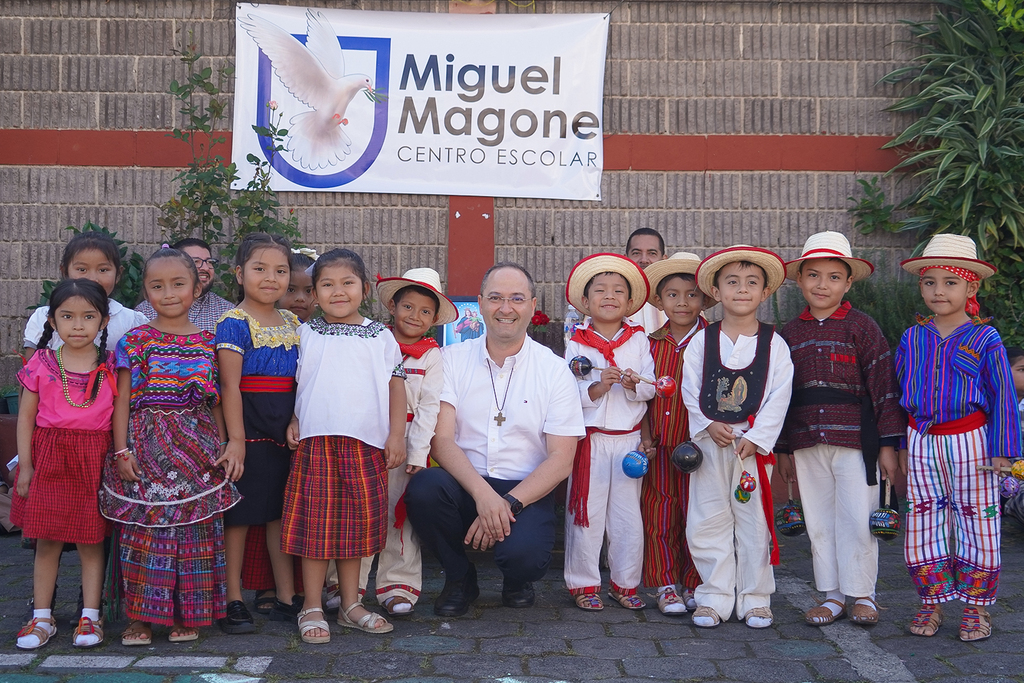 El padre Rafael Bejarano comparte un momento de cercanía y alegría con los estudiantes del Centro Educativo Miguel Magone durante su visita a Guatemala.